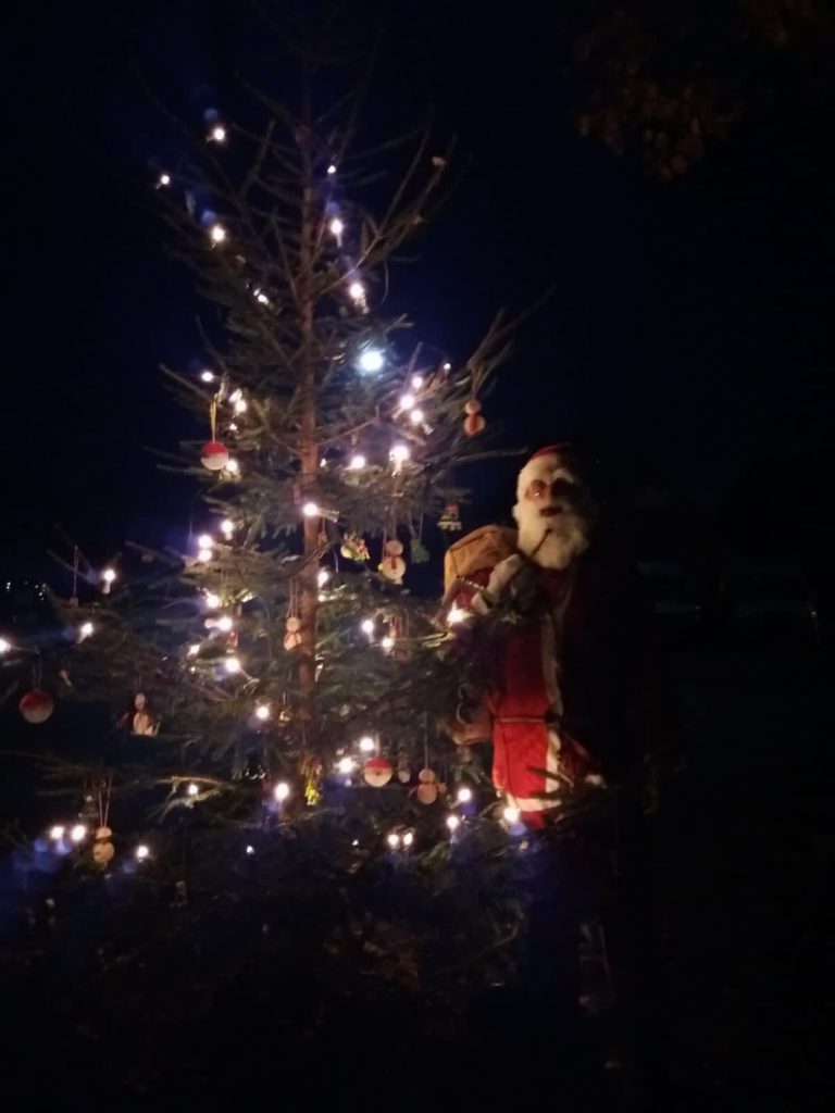 Der Weihnachtsbaum leuchtet auf dem Dorfplatz