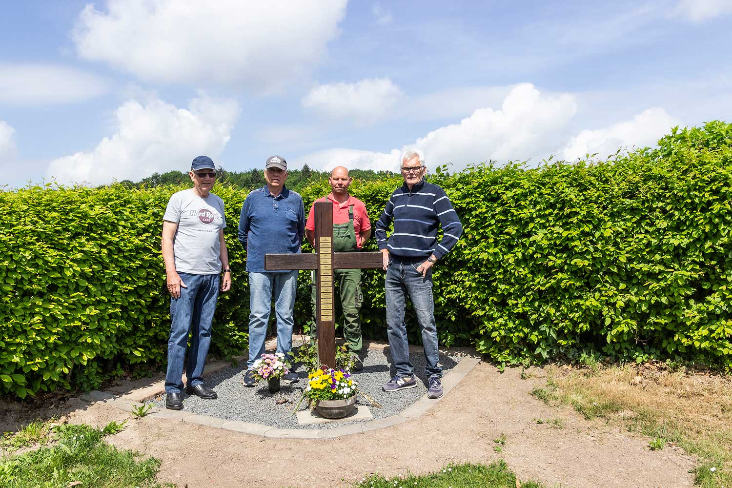 4 Vereinsmitglieder vor dem Kreuz auf dem Selbecker Friedhof