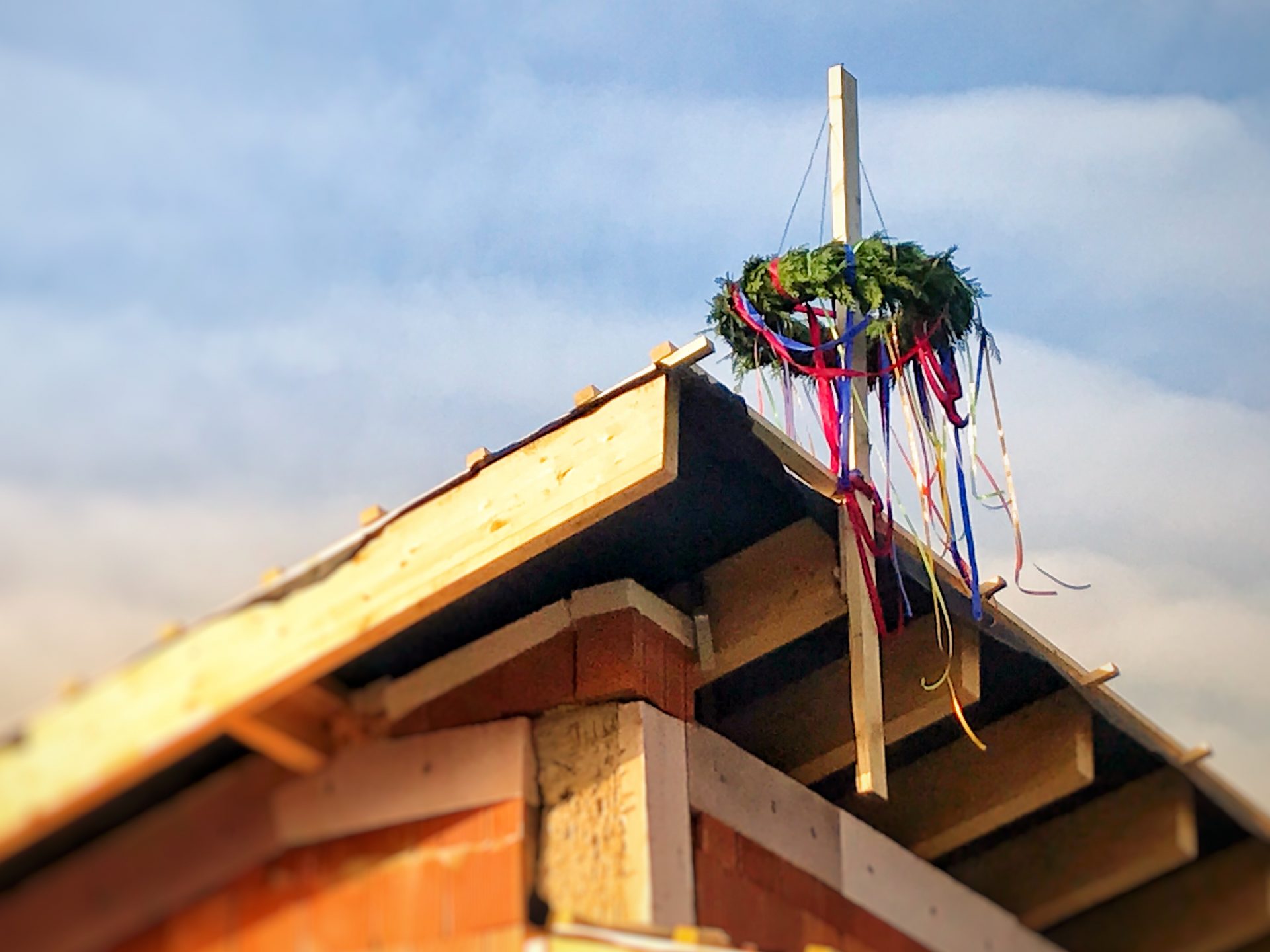 Bunter Richtkranz auf dem Dach des Dorfgemeinschaftshauses.