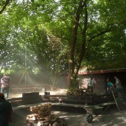 Helfer begradigen den Platz an der Grillhütte